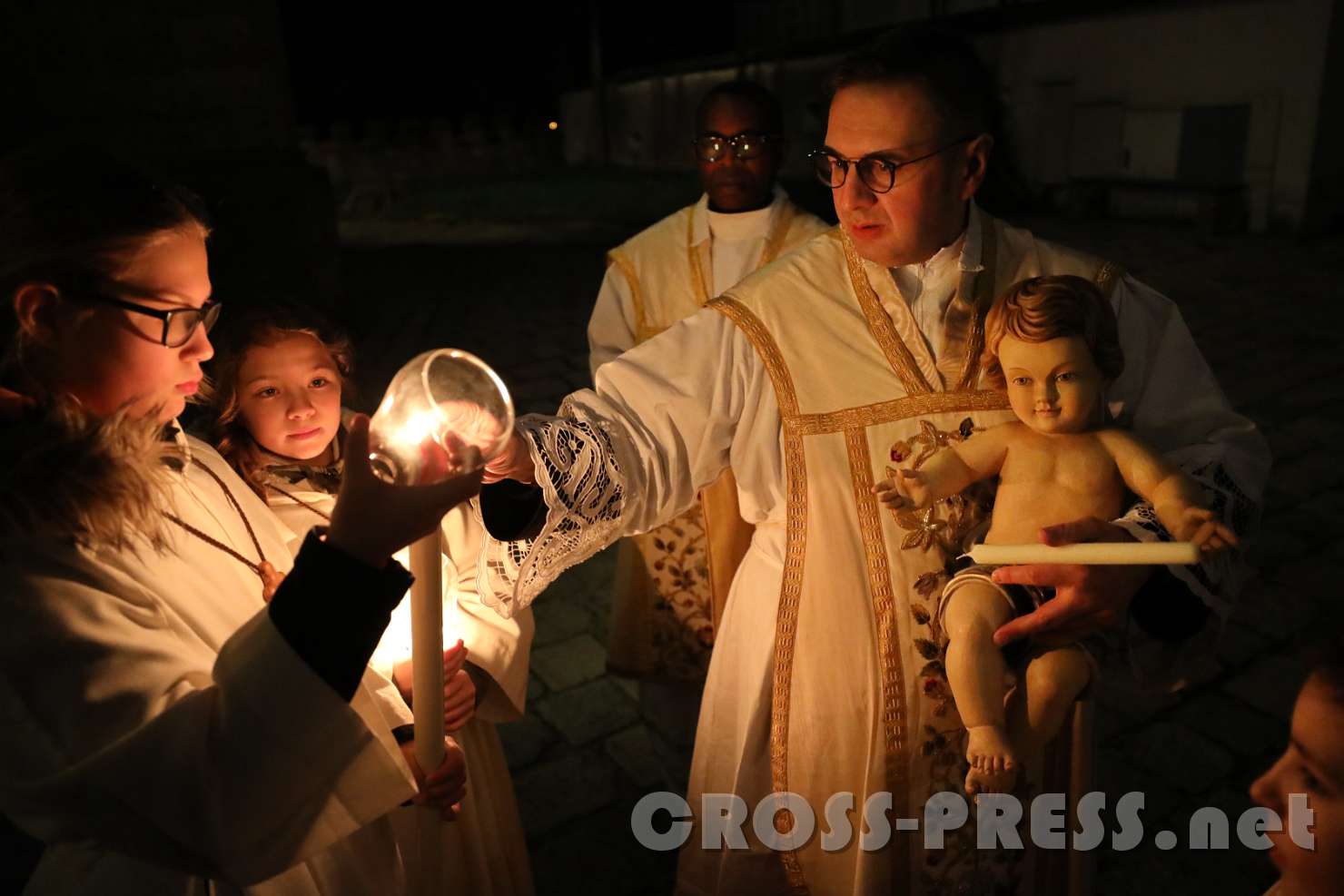 2017.12.24_23.57.21.JPG - Pfarrer Vidović mit dem "Christkind" entzündet Prozessionskerze, vor dem Einzug zur Mette.