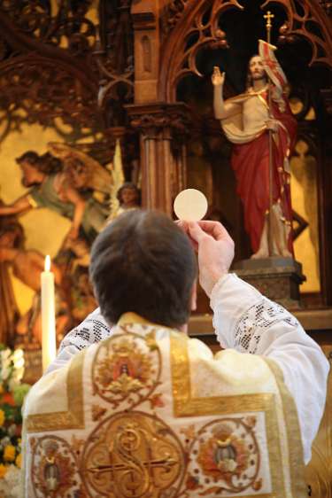 ErstKommunion in Wolfsbach Da die Pfarrkirche in Wolfswbach keinen Volksaltar hat, wird die Elevation zum Hauptaltar hin, hier vor dem Auferstandenen, gemacht.
