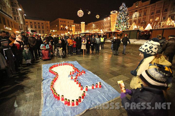 2010.12.04_18.01.48.jpg - Am Hauptplatz gegen�ber dem Adventmarkt formten die Teilnehmer, darunter viele Kinder, mit ihren Kerzen einen Embryo.