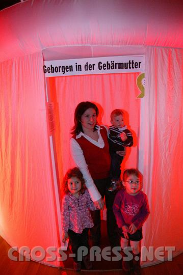 2009.01.11_16.23.14.JPG - Vor dem Eingang ins "Geb�rmutterzelt": Andrea Pichler, Mutter zweier kleiner Kinder, gestaltete Ausstellungsfolder und Logo.