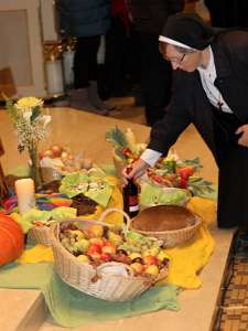 Klosterkirchen Kirtag Eine Nonne legt Wein als Erntedankgabe vor Altar hin.